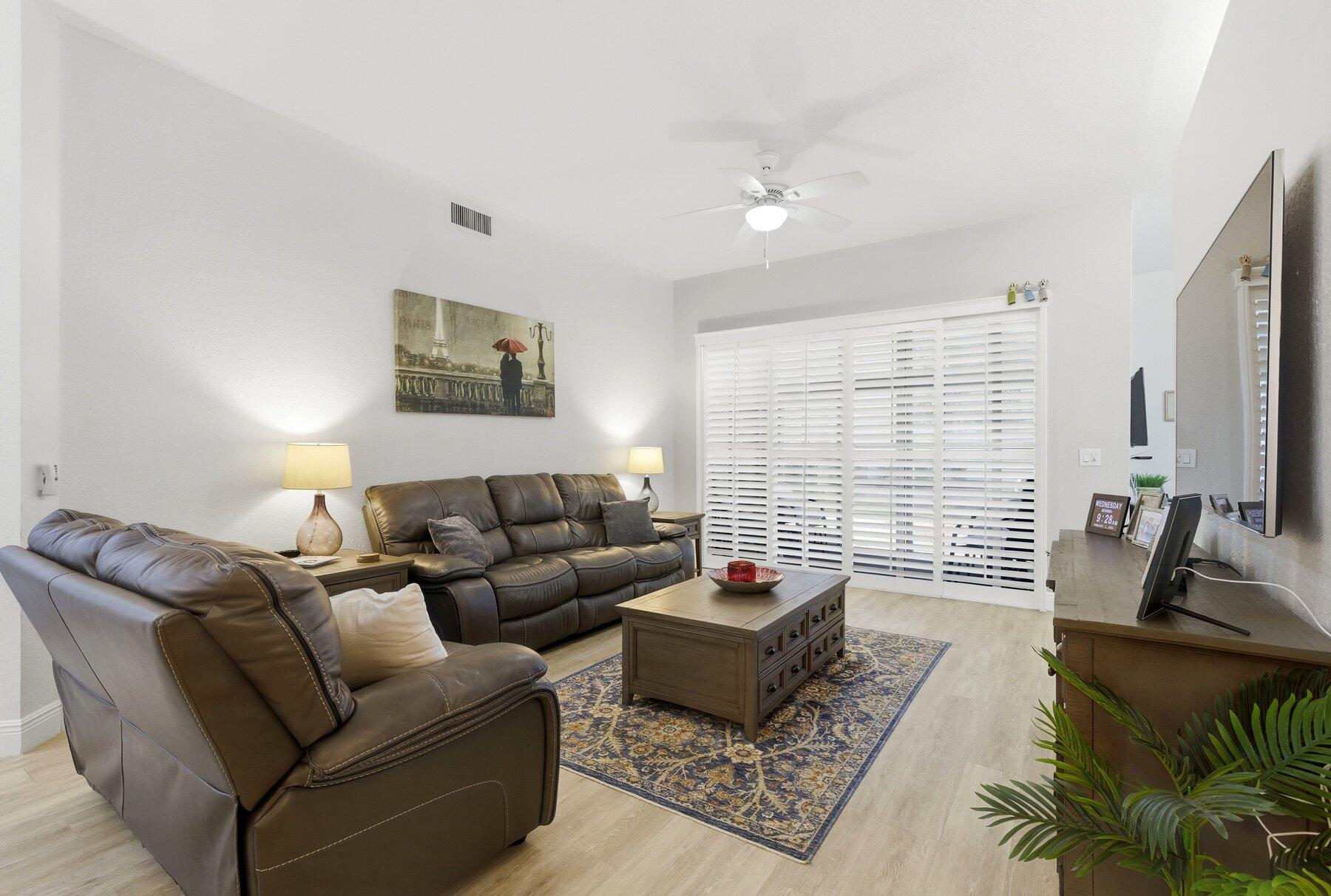 7961 Exeter Boulevard East, Unit 102 Tamarac, FL 33321 - Photo 5 of 46 a living room with furniture and a large window