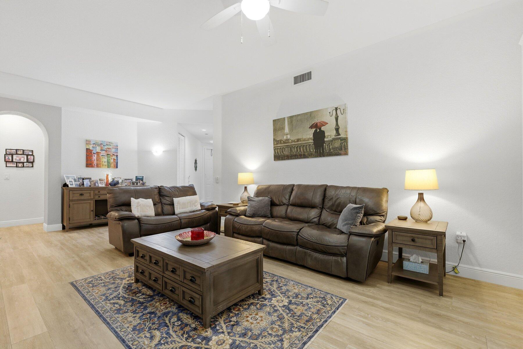 7961 Exeter Boulevard East, Unit 102 Tamarac, FL 33321 - Photo 6 of 46 a living room with furniture a rug and a lamp