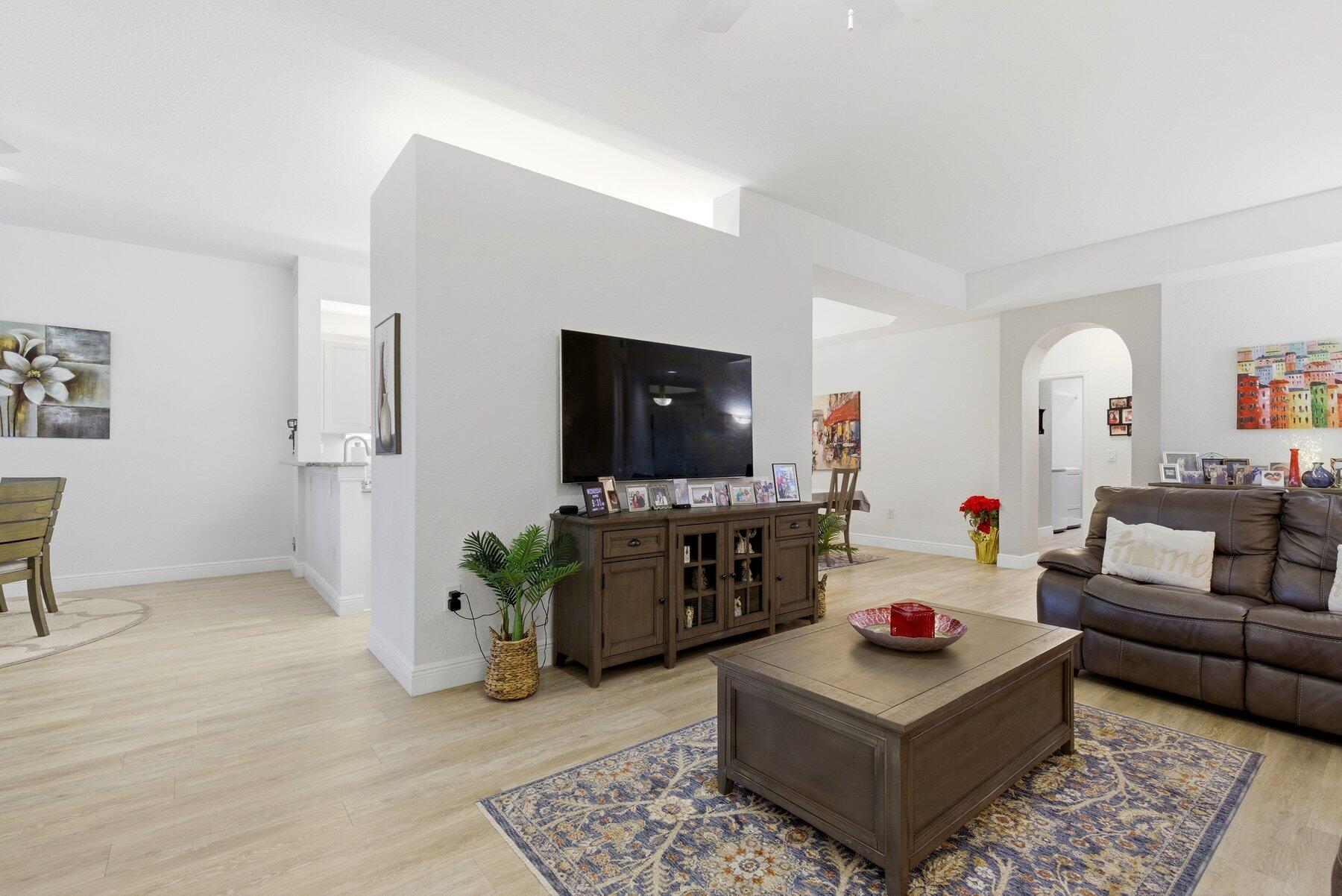 7961 Exeter Boulevard East, Unit 102 Tamarac, FL 33321 - Photo 7 of 46 a living room with furniture and a flat screen tv