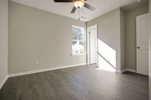 a view of empty room with wooden floor