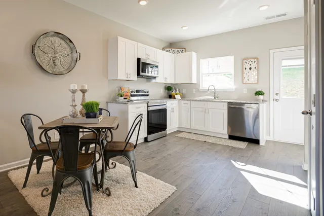 a kitchen with granite countertop white cabinets and white appliances