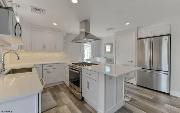 a kitchen with a refrigerator sink and cabinets