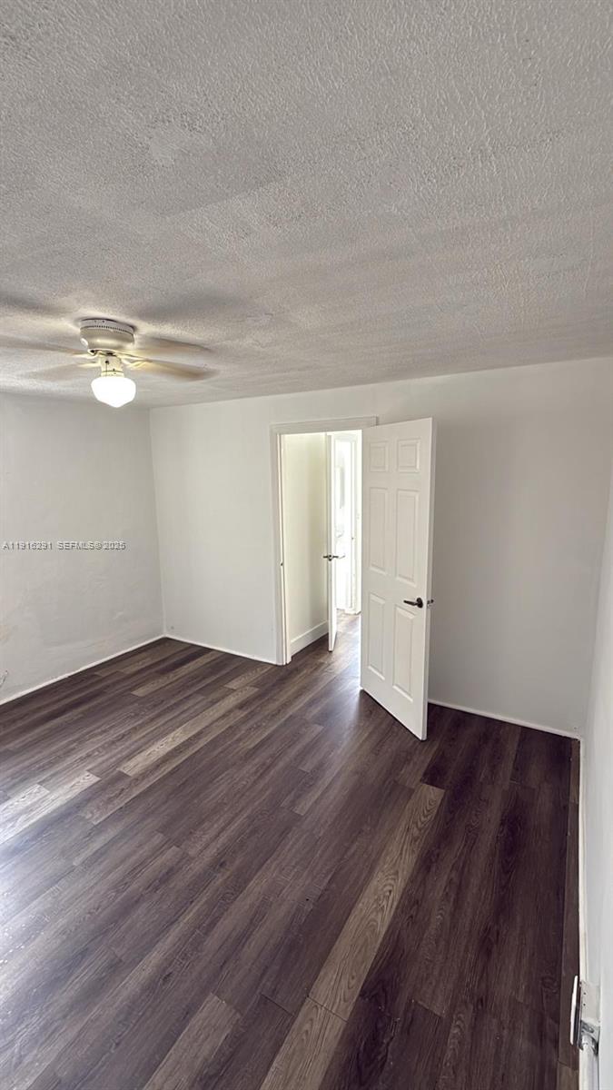 10680 Southwest 172nd Street, Unit 106271 Miami, FL 33157 - Photo 4 of 5 a view of a room with wooden floor and white walls