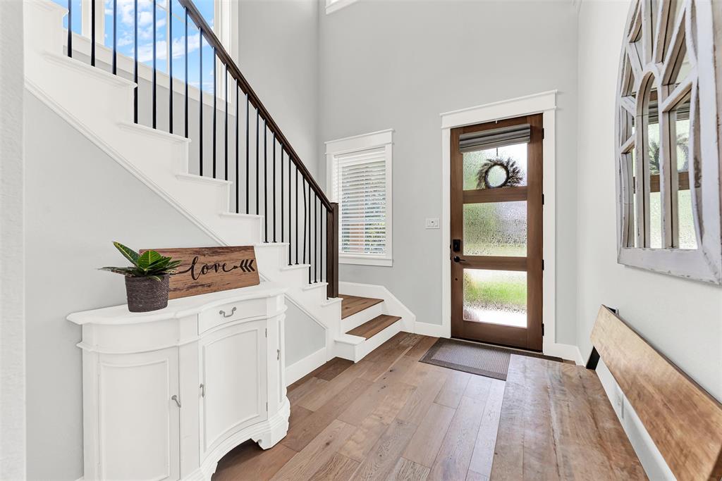 452 Jones Street Grapevine, TX 76051 - Photo 3 of 38 The foyer introduces you to all the resplendent pleasures this home offers! Enjoy light color hardwood floors and gorgeous staircase with wood steps.