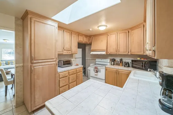 a kitchen with stainless steel appliances granite countertop a refrigerator and a stove top oven