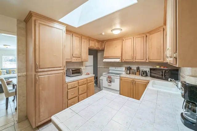 a kitchen with stainless steel appliances granite countertop a refrigerator and a stove top oven