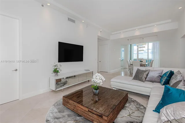 a dining room with furniture a chandelier and wooden floor