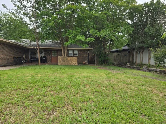 a view of a house with a yard and trees