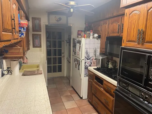 a kitchen with stainless steel appliances granite countertop a refrigerator and a stove top oven