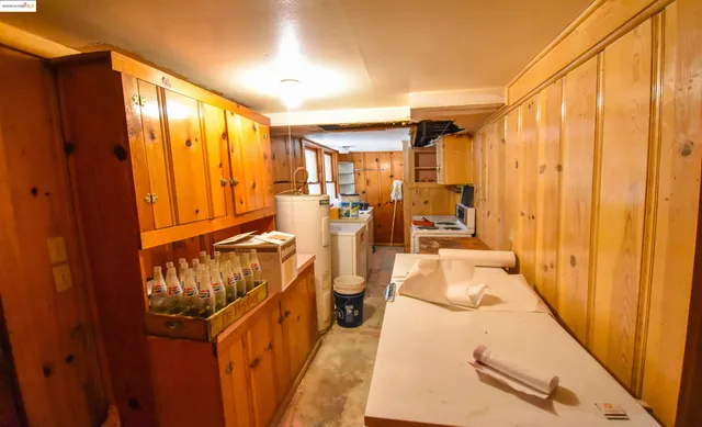 a kitchen with sink a refrigerator and wooden cabinets