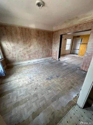 a view of an empty room with a fireplace and a window