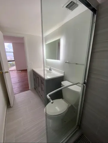 a bathroom with a toilet a sink and mirror