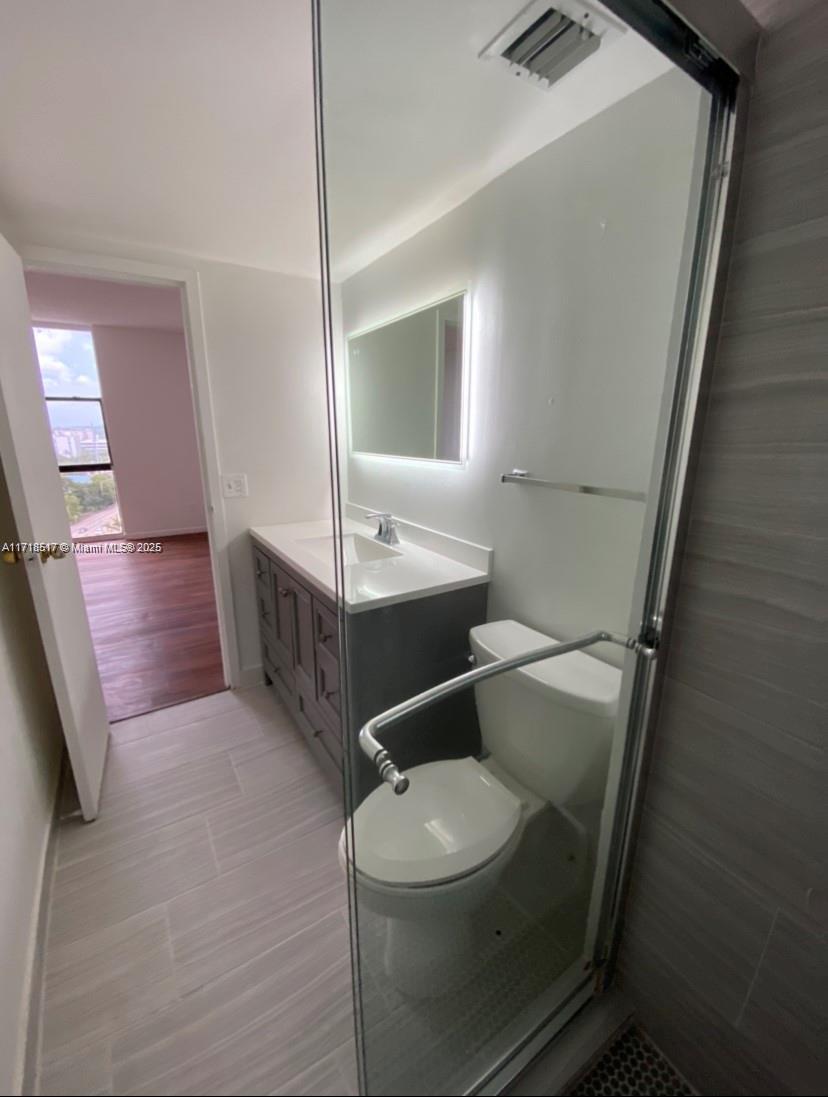 13499 Biscayne Boulevard, Unit 1507 North Miami, FL 33181 - Photo 22 of 34 a bathroom with a toilet a sink and mirror