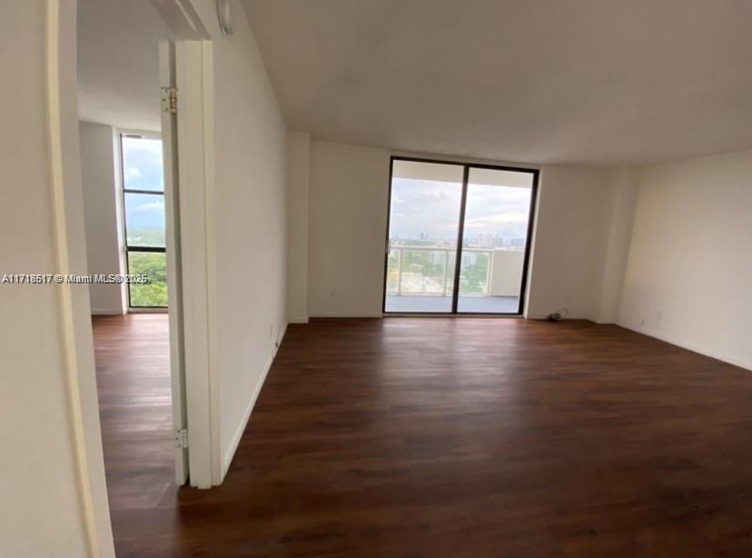 13499 Biscayne Boulevard, Unit 1507 North Miami, FL 33181 - Photo 25 of 34 an empty room with wooden floor and windows