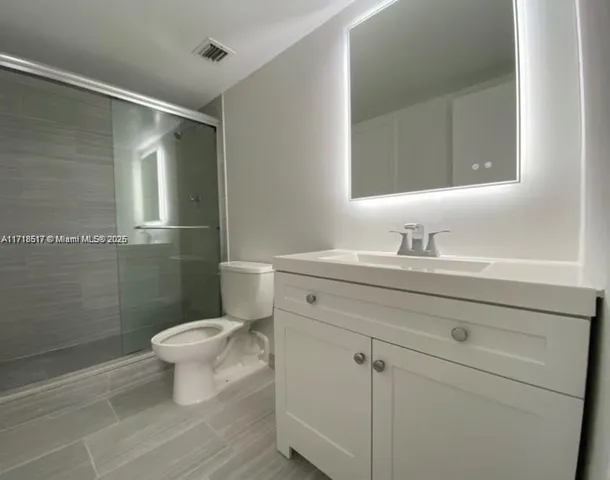 a bathroom with a sink toilet a mirror and shower