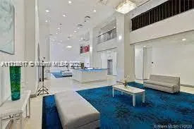 a living room with couches and kitchen view with wooden floor