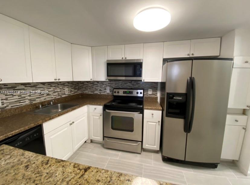 13499 Biscayne Boulevard, Unit 1507 North Miami, FL 33181 - Photo 6 of 34 a kitchen with granite countertop white cabinets and stainless steel appliances