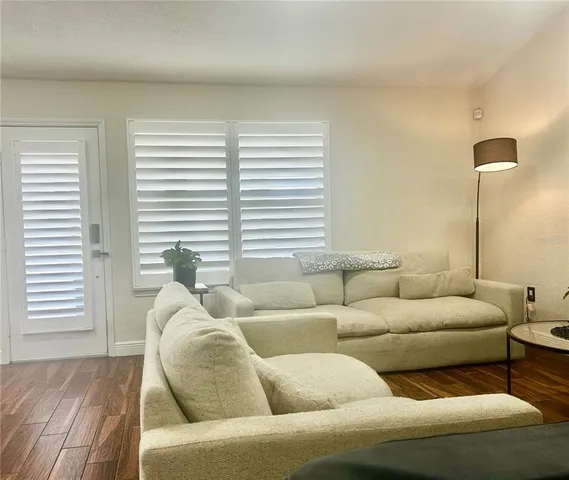 a bathroom with a granite countertop toilet a sink a mirror and shower curtain