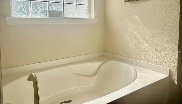 a bedroom with a bed and a chandelier fan