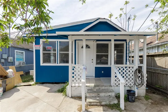an empty room with wooden floor fireplace and windows