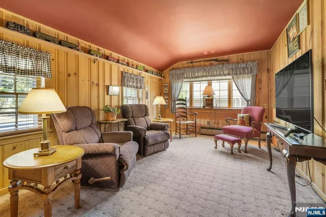 a living room with furniture a flat screen tv and a large window