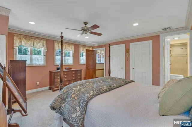 a spacious bedroom with a large bed and a chandelier