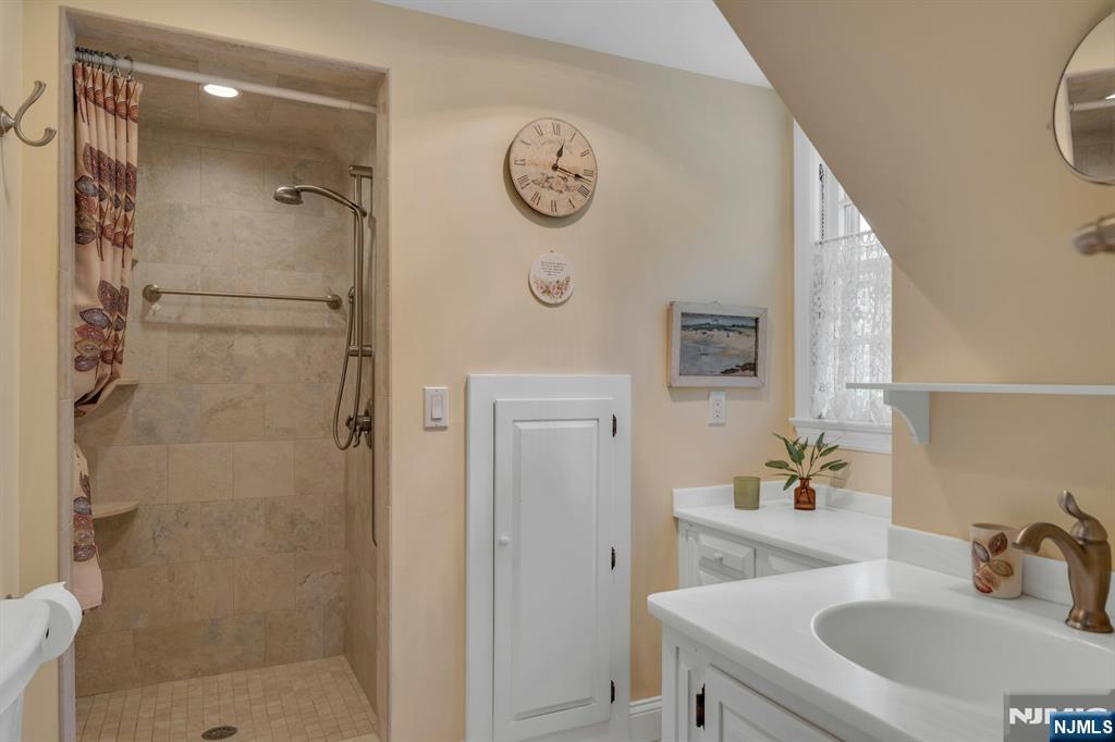 174 Paramus Road Paramus, NJ 07652 - Photo 29 of 45 a bathroom with a shower sink and mirror