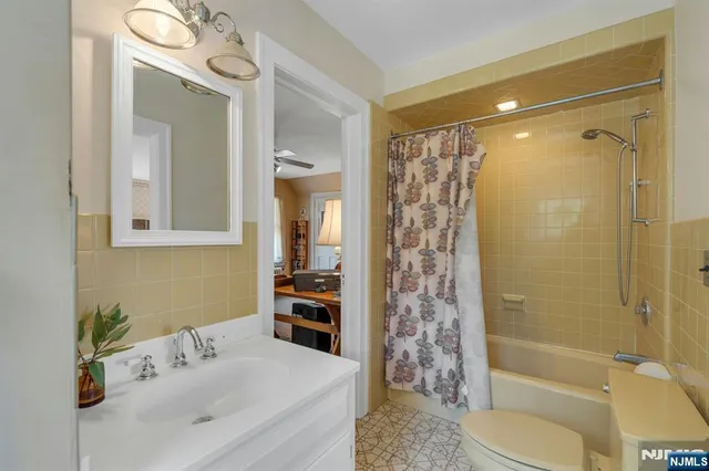 a bathroom with a bathtub shower sink vanity and toilet