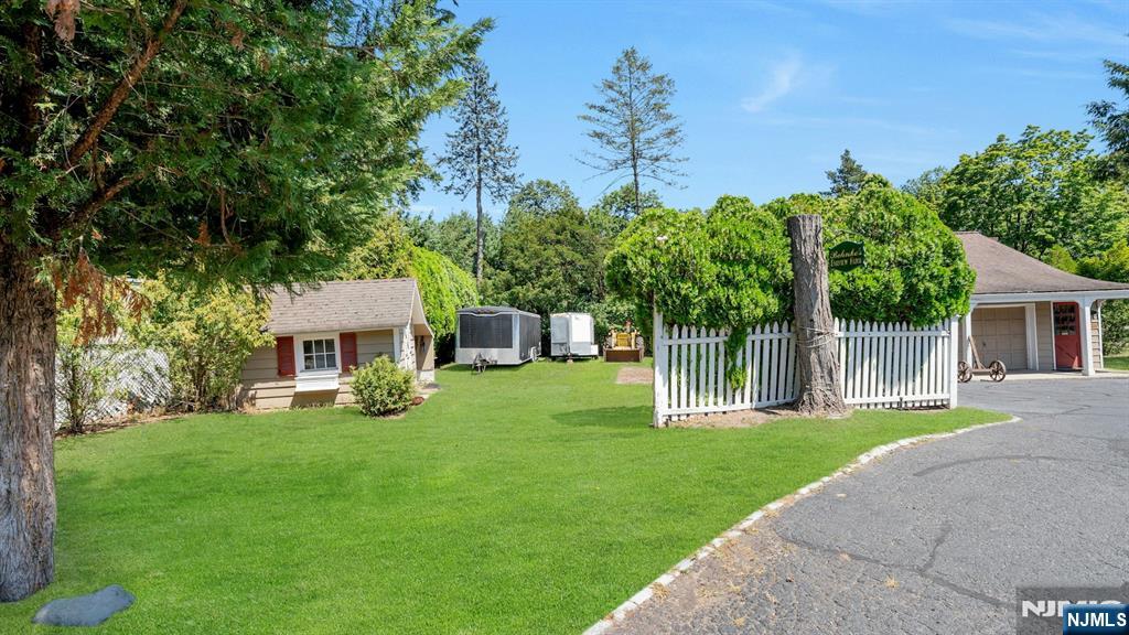 174 Paramus Road Paramus, NJ 07652 - Photo 43 of 45 a front view of a house with a garden and yard