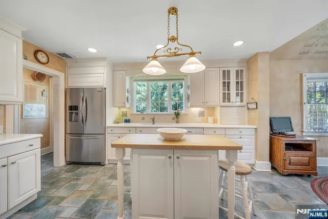 a kitchen with a refrigerator a sink and dishwasher a oven with white cabinets