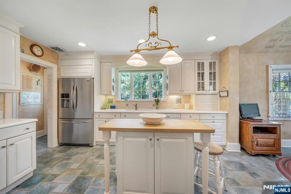 174 Paramus Road Paramus, NJ 07652 - Photo 10 of 45 a kitchen with a refrigerator a sink and dishwasher a oven with white cabinets
