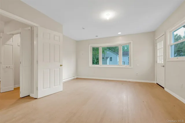 an empty room with windows and closet area