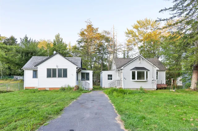 a front view of a house with a garden and trees