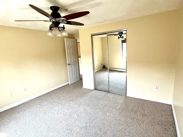 an empty room with a mirror and a fan