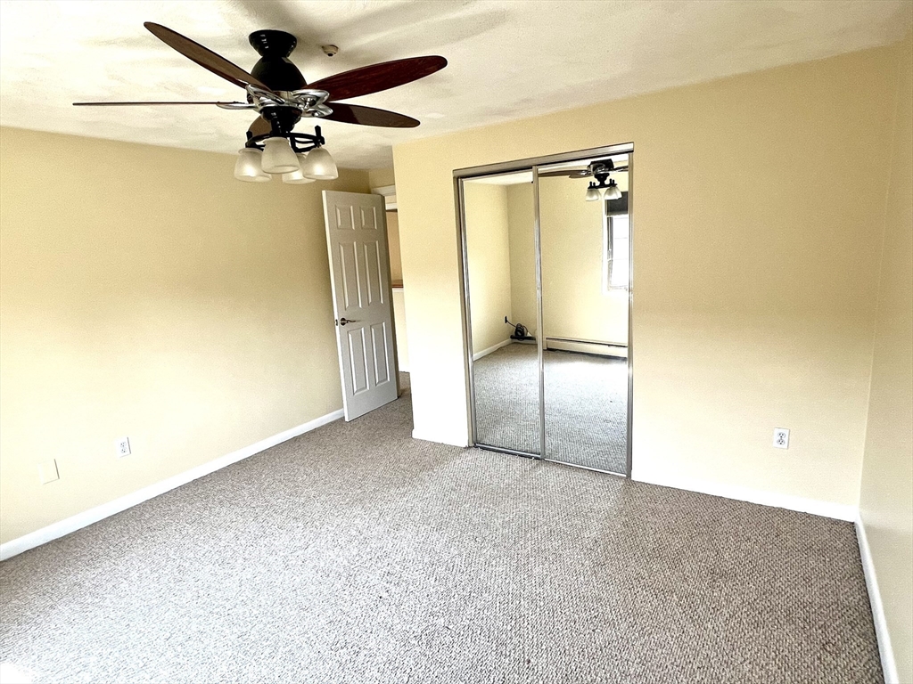 103 Grove Street, Unit 337 Rockland, MA 02370 - Photo 13 of 16 an empty room with a mirror and a fan