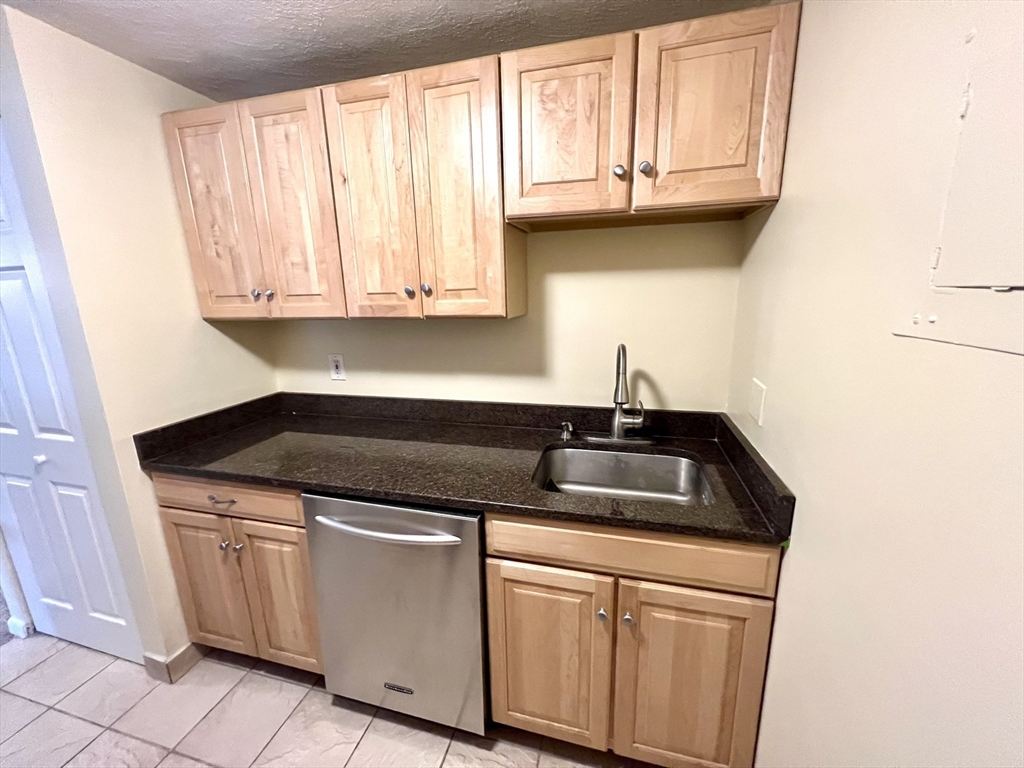 103 Grove Street, Unit 337 Rockland, MA 02370 - Photo 4 of 16 a kitchen with granite countertop a sink and a window