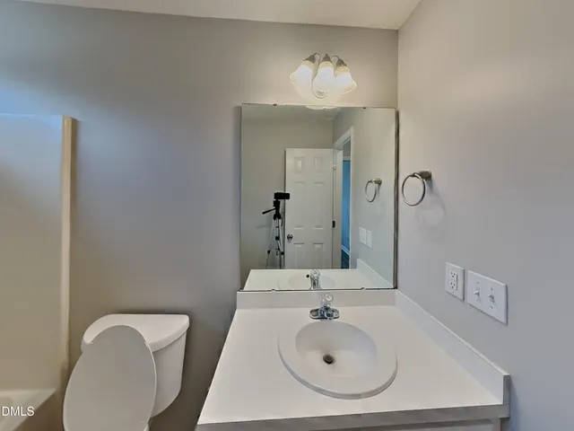 a bathroom with a sink mirror and toilet