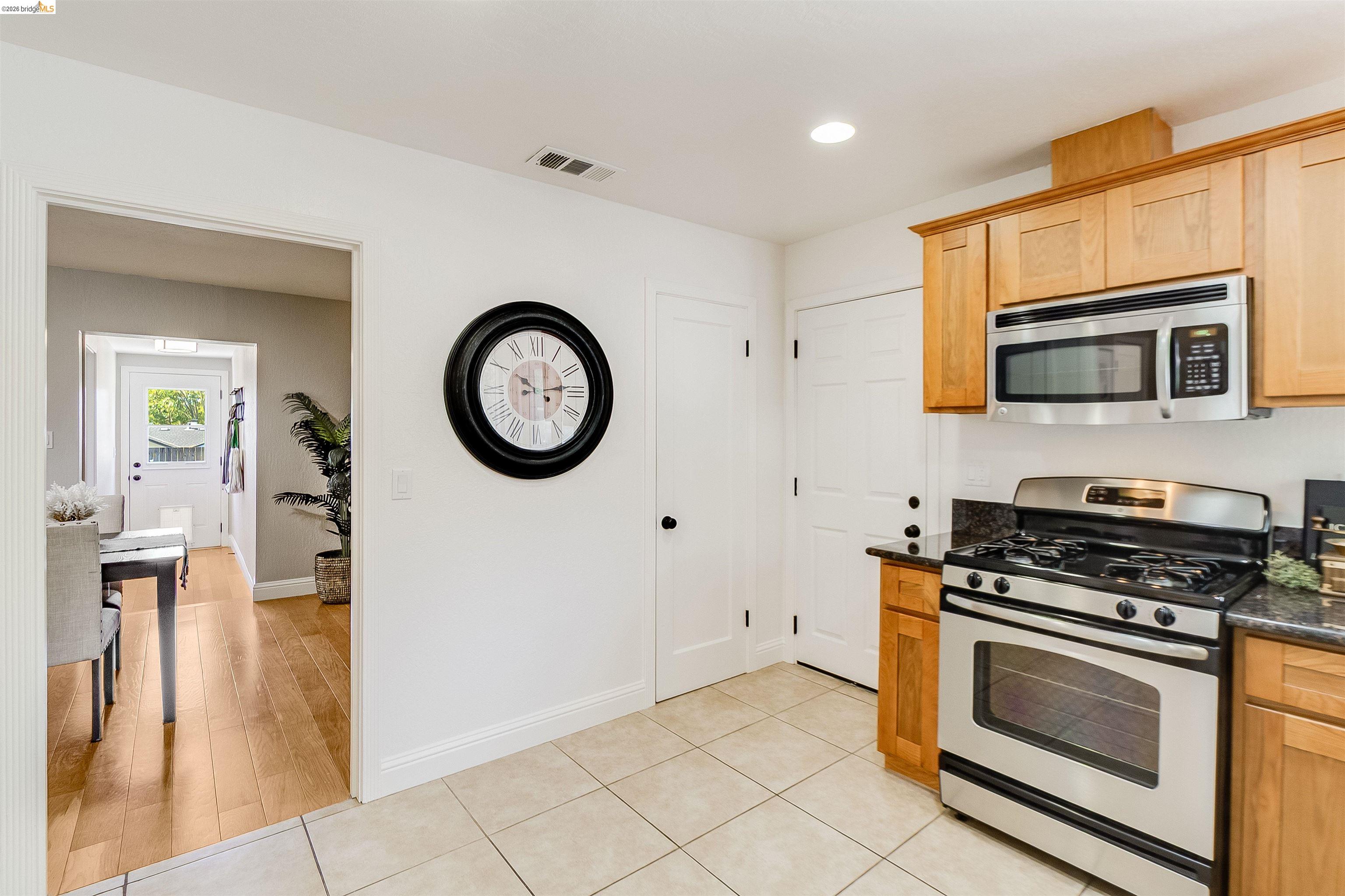 346 Valley View Road Pleasant Hill, CA 94523 - Photo 19 of 57 Kitchen featuring stainless steel range with overhead microwave, granite countertops, and wood cabinetry