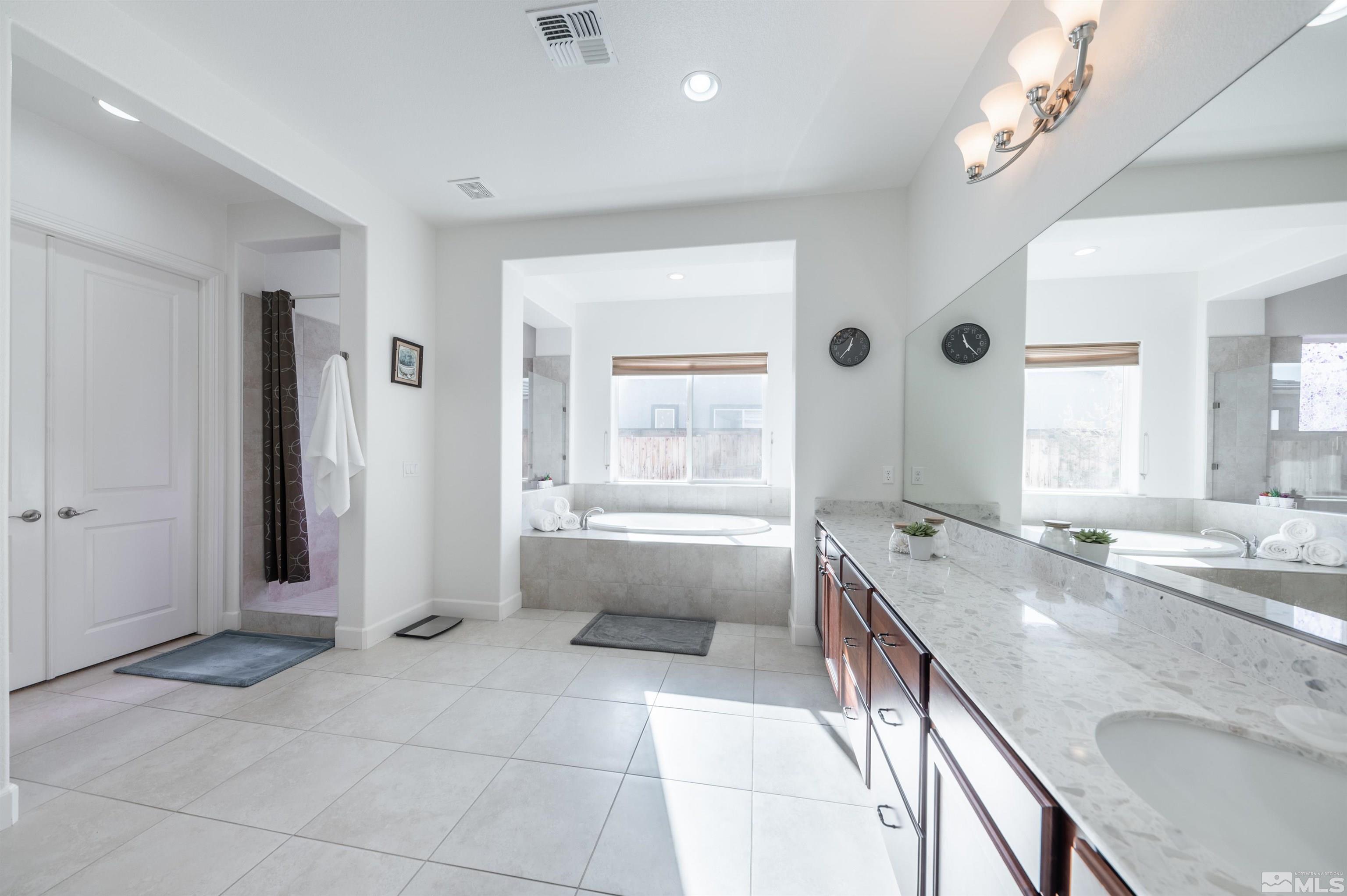 9835 Gainsborough Lane Reno, NV 89521 - Photo 23 of 40 a spacious bathroom with a granite countertop tub sink and mirror