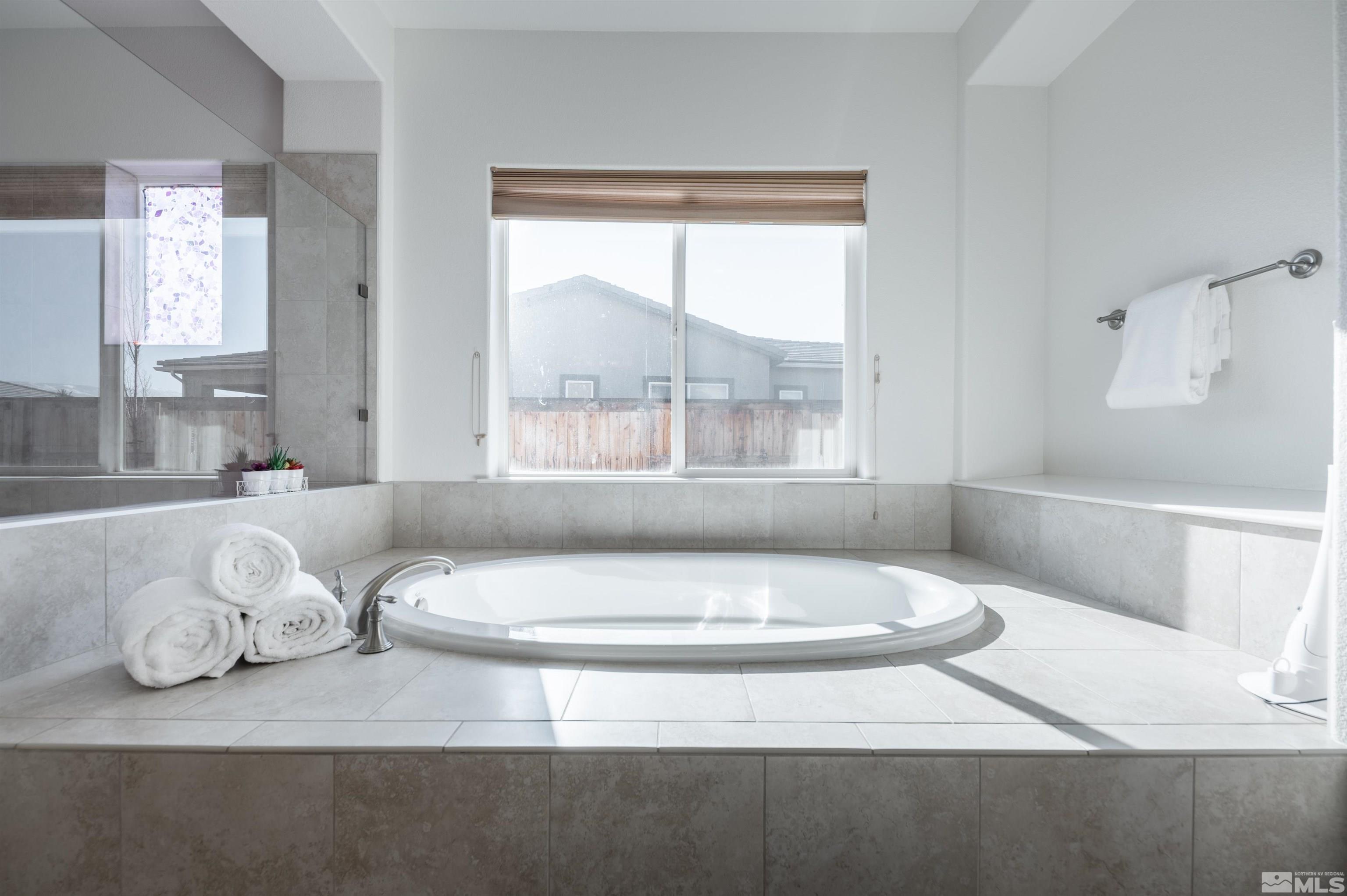 9835 Gainsborough Lane Reno, NV 89521 - Photo 24 of 40 a bathroom with a sink and bathtub with window