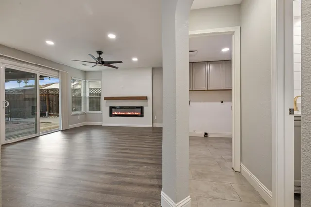 a view of a hallway with wooden floor and a kitchen