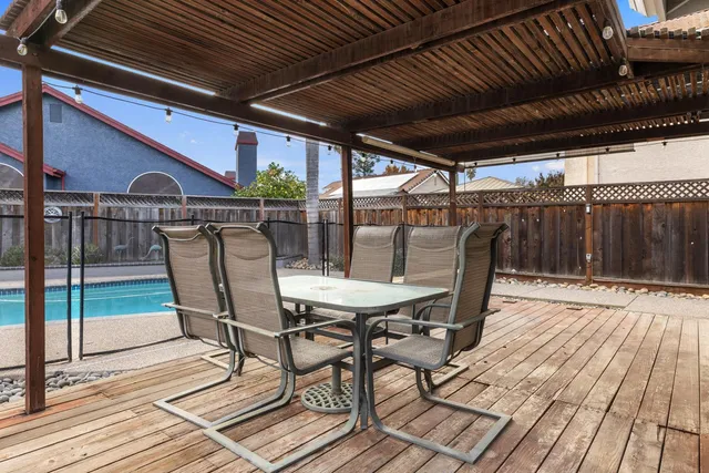 a view of a roof deck with table and chairs and wooden floor