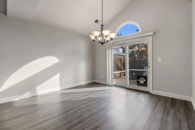 a view of a livingroom with wooden floor a chandelier