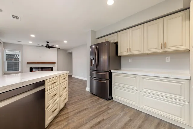 a kitchen with stainless steel appliances white cabinets and a refrigerator