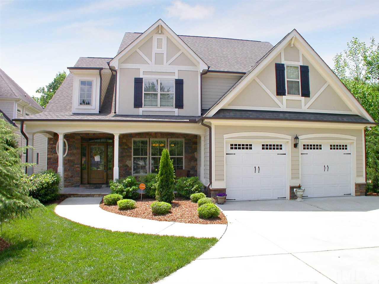 a front view of a house with a yard and plants