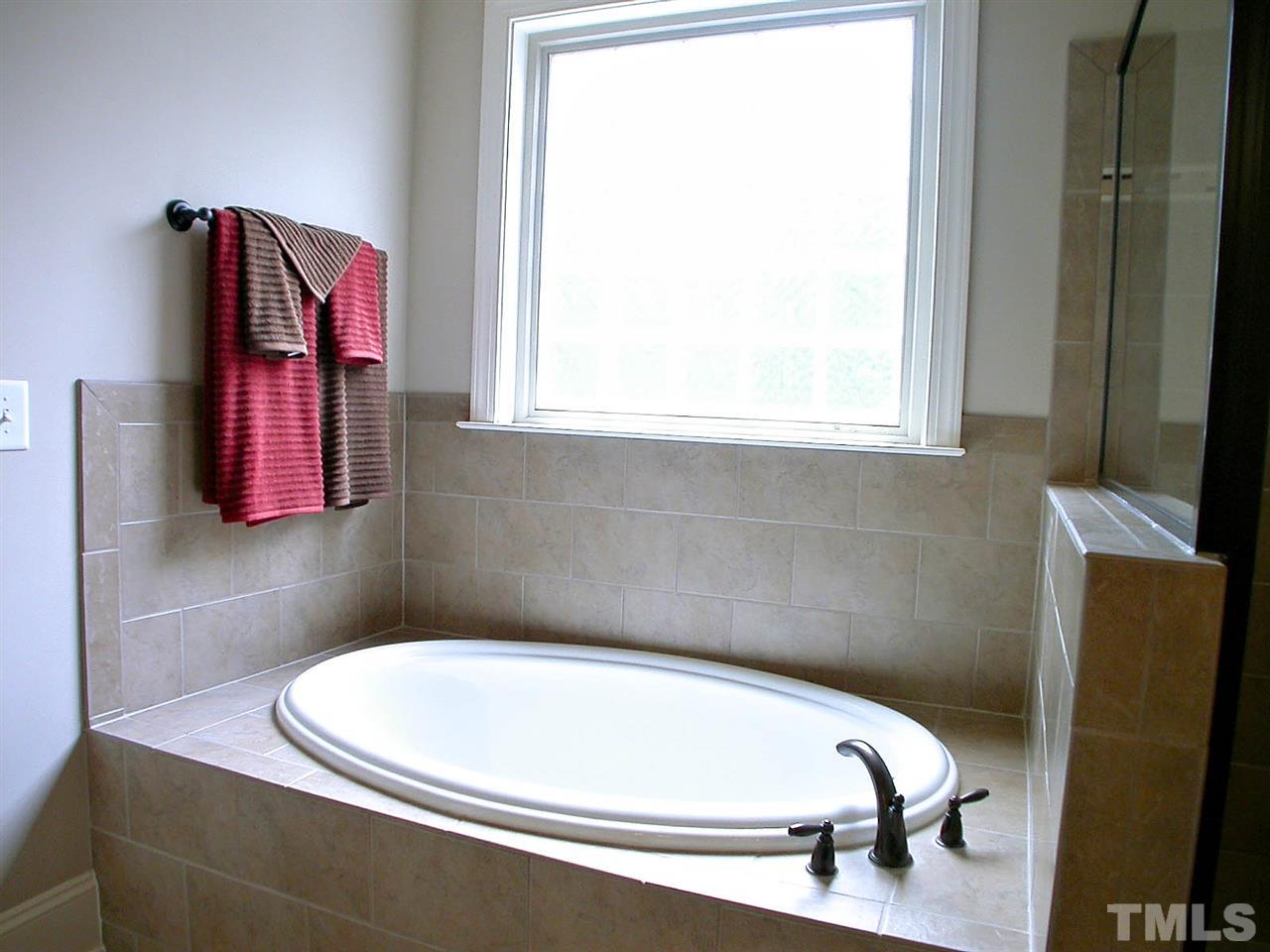12349 Beestone Lane Raleigh, NC 27614 - Photo 14 of 25 a bathroom with a bathtub and a window