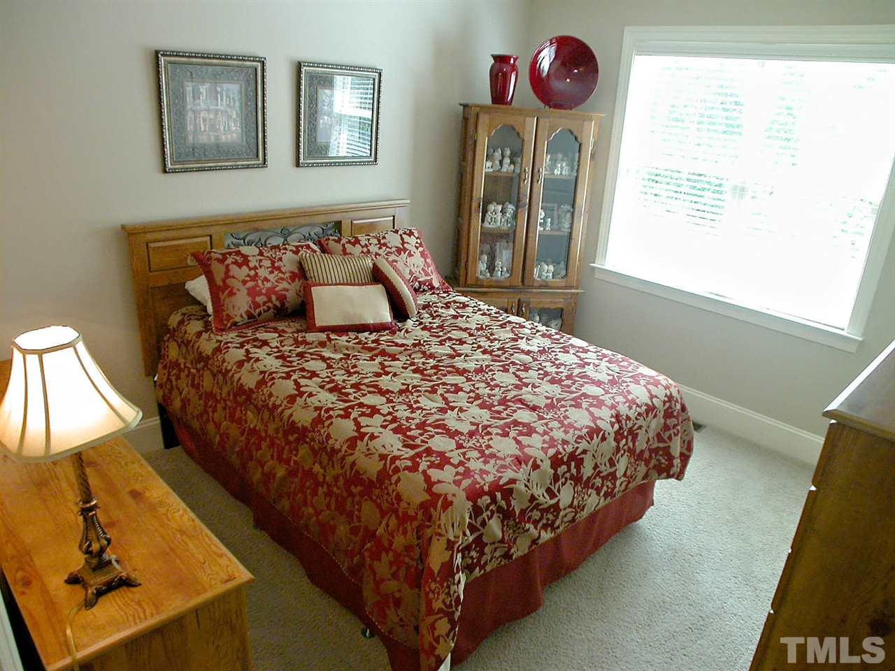 12349 Beestone Lane Raleigh, NC 27614 - Photo 16 of 25 a bed sitting in a bedroom next to a window
