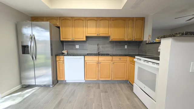 a kitchen with stainless steel appliances a refrigerator sink and cabinets