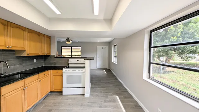 a kitchen with stainless steel appliances granite countertop a stove a sink and a refrigerator