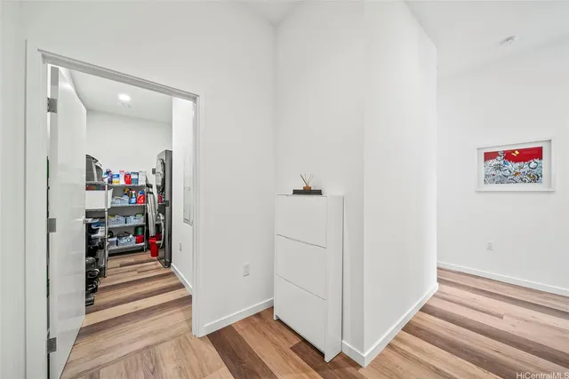 a view of a hallway with wooden floor and closet